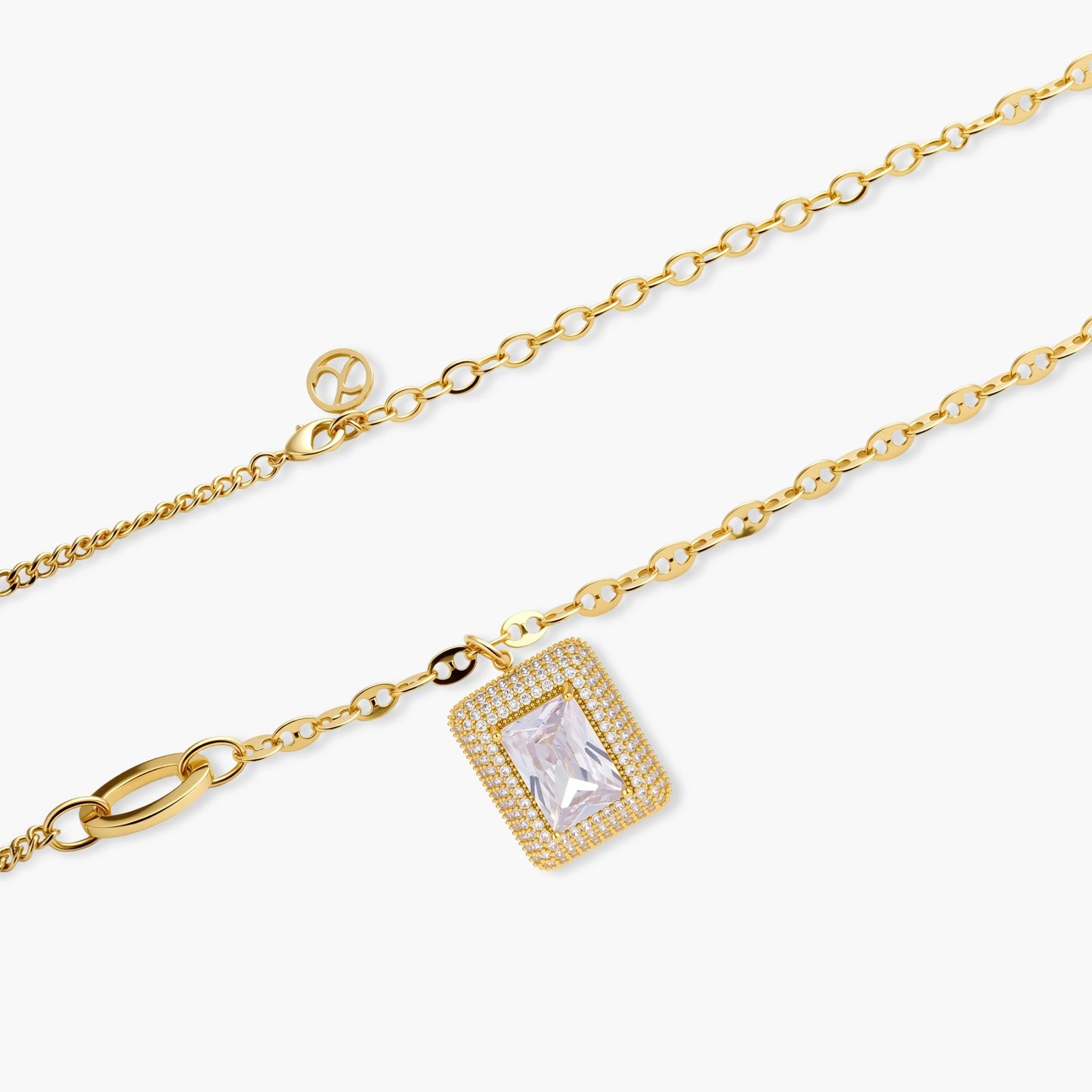 Gold-plated jewelry set with rectangular cubic zirconia stones in pave halo settings on cream background