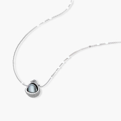 Elegant spherical pendant necklace and earrings set featuring crystal-pavé bottom half in gold or silver finish on white background.