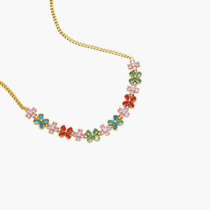 Gold-plated jewelry set with pink, turquoise and red flower-shaped cubic zirconia stones, featuring necklace, earrings and bracelet.