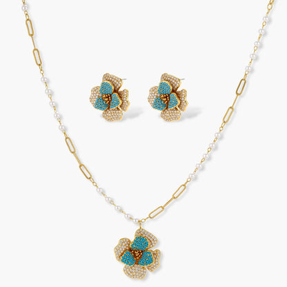 14K gold-plated floral jewelry set with blue cubic zirconia centers and pearl chain details on white background.