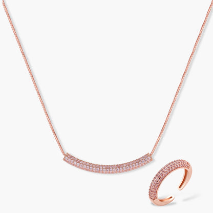 Rose gold jewelry set with pavé cubic zirconia stones including curved necklace, hoop earrings, and adjustable ring on cream background.