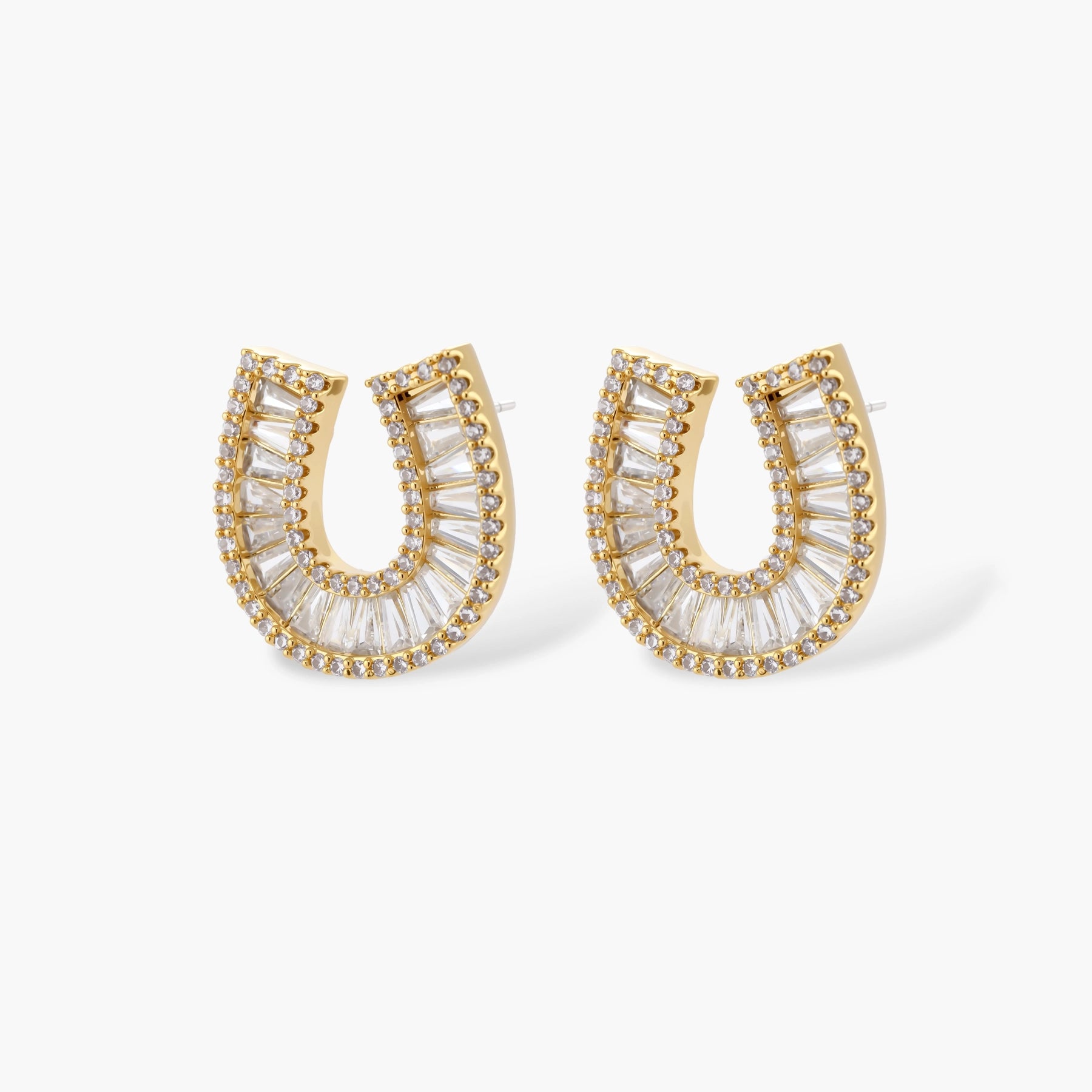 Sparkling horseshoe-shaped jewelry set with AAA cubic zirconia in gold-plated and white gold finishes on cream background.