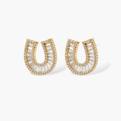 Sparkling horseshoe-shaped jewelry set with AAA cubic zirconia in gold-plated and white gold finishes on cream background.